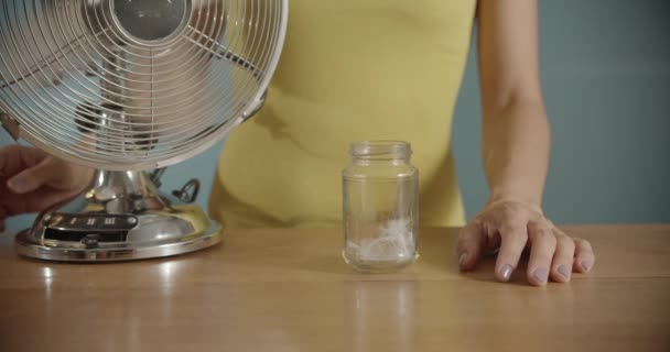 Közelkép Egy Kezéről Amint Bekapcsolja Elektromos Ventilátort Tollat Fúj Levegőbe — Stock videók