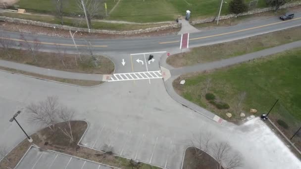 Drone Segue Tiro Uma Motocicleta Deixando Estacionamento Dirigindo Estrada Abaixo — Vídeo de Stock