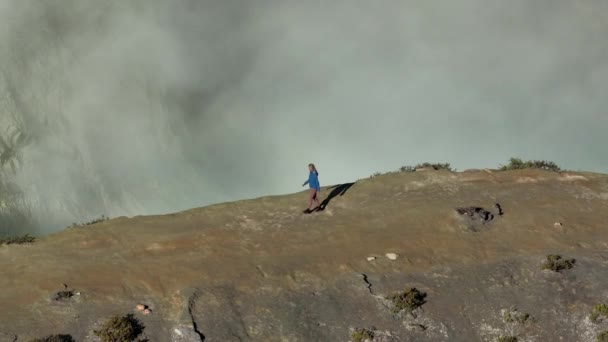 妇女沿着活火山边缘徒步旅行 令人印象深刻的火山口湖景 — 图库视频影像
