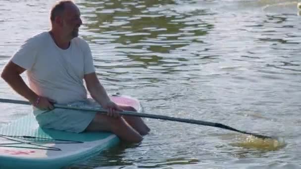 Idősebb Aktív Férfi Egy Táblán Egy Közepén Evezővel Vízzel Játszik — Stock videók