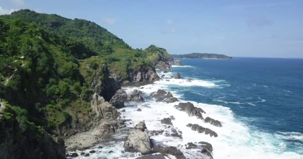 阳光明媚的日子里 在海滩上拍下了岩石海岸 海浪汹涌 印度尼西亚热带海岸线 印度尼西亚日惹 — 图库视频影像