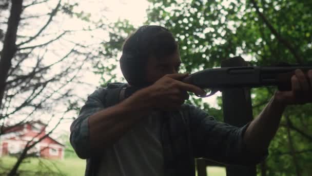 若い男は森の中で訓練のための散弾銃を持っています ジョージア銃はスローモーションを撃つ — ストック動画