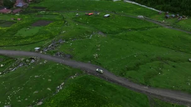 Aerial View Car Driving Unpaved Road Midst Green Meadow Ushguli — Stok Video