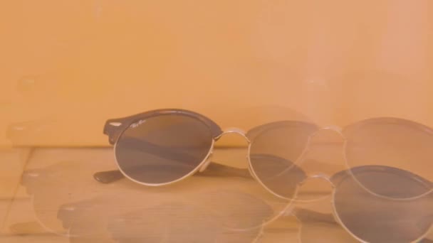 Ray Ban Glasses Resting Wooden Table Orange Background Viewed Kaleidoscope — Stock Video