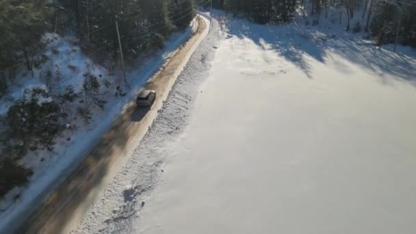 Drone Passa Sopra Veicolo Che Guida Lungo Una Strada Invernale — Video Stock