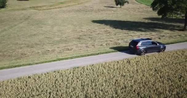 Een Volvo Auto Rijdt Een Kleine Weg Buurt Van Een — Stockvideo