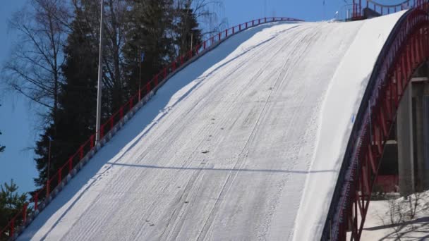 雪のトラックにジャンプスキージャンパーのショットを閉じます — ストック動画