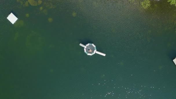在阳光灿烂的日子里 鸟瞰着一只在日落湖上的充气圆形木筏上沐浴的女游客 — 图库视频影像