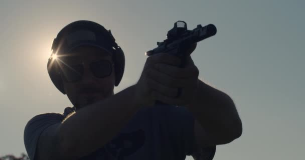 Man Skjuter Pistol Silhouette Med Sunburst — Stockvideo