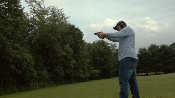 Homem Dispara Pistola Como Câmera Deriva Para Frente — Vídeo de Stock