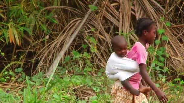 Mladá Černošky Dívka Nese Dítě Sourozence Zádech Při Chůzi Džunglí — Stock video