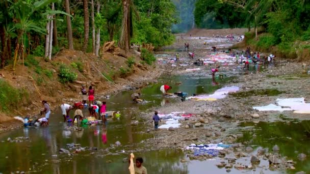 アフリカの人々は水の流れの中で服を洗う 共同水道には水道水がないため 洗濯は 岩を洗う または料理で行われます — ストック動画