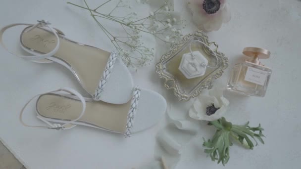 新娘的鞋子整齐地摆放在桌子上 上面摆放着香水 珠宝和鲜花 — 图库视频影像