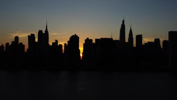 シルエットのマンハッタンのスカイラインの非常に遅いトラックの空中ショット豪華な日没で — ストック動画