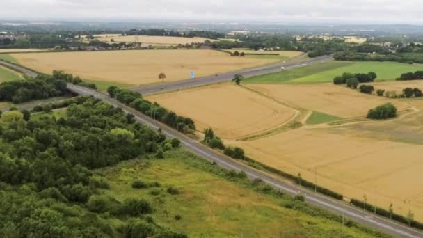 農村部の農業牧草地やフィールド全体の空中ビュー英国の田舎の高速道路に拡大 — ストック動画