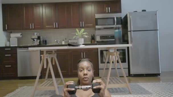 黒人女性が両手で体重を量りながら居間に腰を下ろしている 4K60 — ストック動画