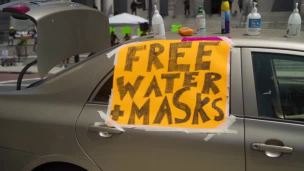 Een Bordje Met Gratis Water Maskers Een Auto Geplakt Bij — Stockvideo