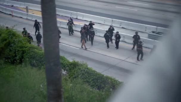 暴動警察のグループはダウンタウンのBlm抗議中に110ハイウェイを手を上げて男を歩く — ストック動画