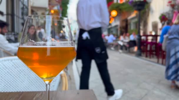 在西班牙的马贝拉老城 在繁忙的旅游街道上喝着一杯清凉的啤酒 模糊了人们坐在外面吃饭的时间 4K开了一枪 — 图库视频影像