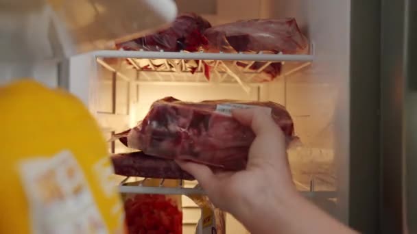 关上手打开冰箱门的视野 把密封红肉放在冰箱架上 — 图库视频影像