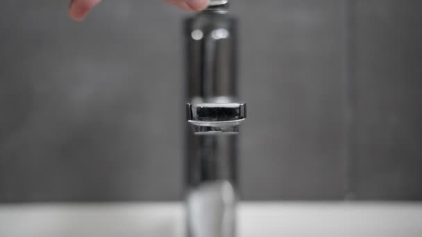 Hand Dreht Das Wasser Einem Badezimmerhahn Aus Edelstahl Vor Einer — Stockvideo