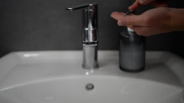 Jovem Aproximando Banheiro Branco Afundar Frente Uma Parede Cinza Seguida — Vídeo de Stock
