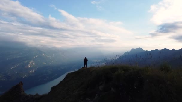 登山者站在瑞士阿尔卑斯山的山顶上 夕阳西下的景色带着一种自由 成功和冒险的感觉俯瞰着布里恩兹湖 — 图库视频影像