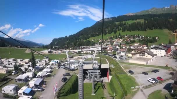 スイスのケーブルカーに乗る ケーブルカーは谷に降ります 村のキャンプ場や山のあるスイスの美しい自然を見ることができます グリソンズ チャーワルデン — ストック動画