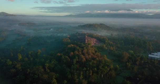美丽的圆形无人驾驶飞机在宏伟的宝罗浮宫周围和印度尼西亚周围的群山上空盘旋 — 图库视频影像