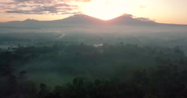日の出にインドネシアのボロブドゥール寺院周辺の山々に降下するドローンは — ストック動画