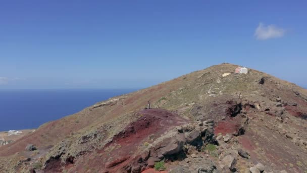 Aerial Orbit Shot Man Standing Top Hill Santorini Imerovigli Background — Stock Video