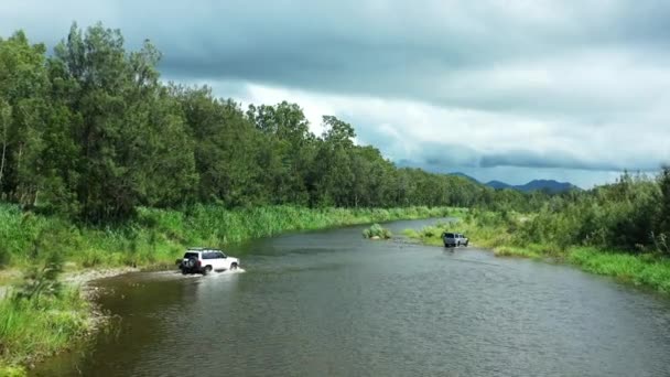 Aerial Drone Four Wheel Drive Vehicles Crossing Flowing Creek Stormy — Stock Video