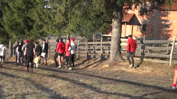 涼しい天気のレースでは 未舗装の農場の道路上でお互いを行使する男性 集団フィットネス時間中に足のレースに友人に挑戦しながら男が落ちる — ストック動画