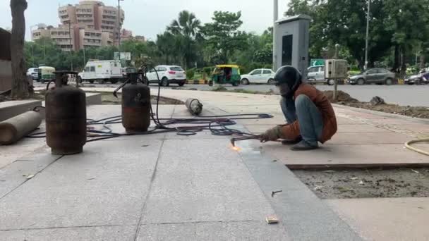 Seorang Pekerja Las Bekerja Pinggir Jalan Lokasi Konstruksi Mengenakan Helm — Stok Video