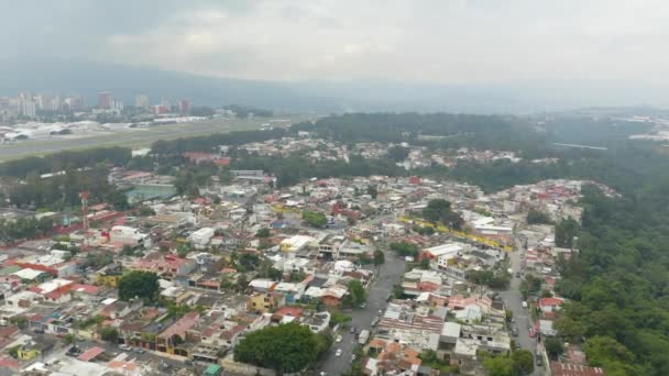 一架无人驾驶飞机在危地马拉城Santa Catarina Palopo镇上空盘旋 在白云笼罩的山脉前看得见跑道 — 图库视频影像