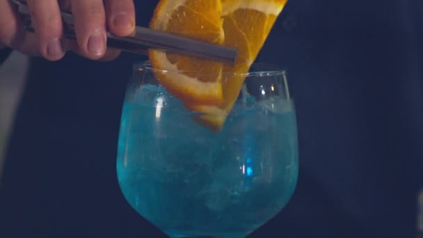 Barman Dodający Plasterki Pomarańczy Niebieskiego Koktajlu Curaao Izolowany Zwolnionym Tempie — Wideo stockowe
