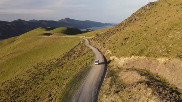 新西兰法式出入口狭长地带日落时在山路上行驶的汽车的空中尾迹 — 图库视频影像