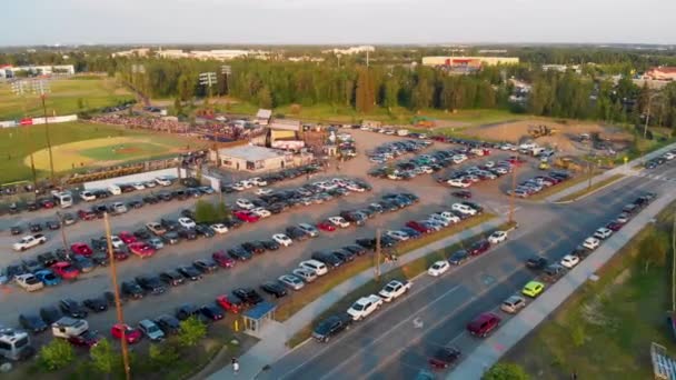 夏の最長の日にアラスカのフェアバンクスで真夜中の太陽クラシック野球の試合中に成長した記念フィールドで駐車場の4Kドローンビデオ — ストック動画
