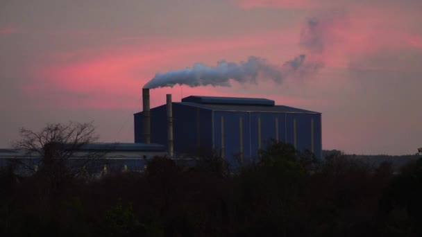 ベトナムのカラフルな夜空に対して製造工場から煙突から出てくる煙の白いパフの前進ショット — ストック動画