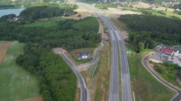 森や湖とポーランドの農村部で空の高速道路の空中ショットを上昇 — ストック動画