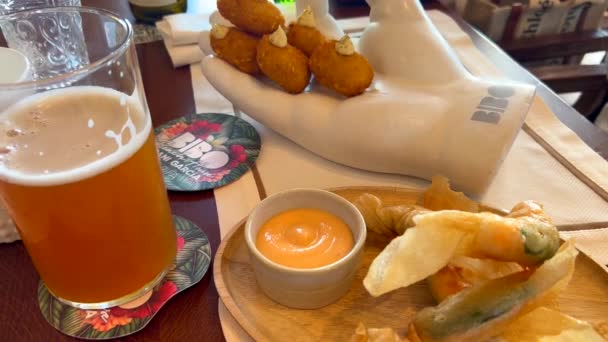 在西班牙著名的丹尼加西亚的塔里法比博海滩餐馆 传统的西班牙羊排配上意大利火腿和虾仁 再加上啤酒 4K杯 — 图库视频影像