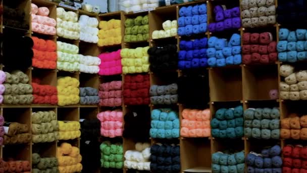 面料商店的高架子上陈列着五颜六色的羊毛球 平底锅右 — 图库视频影像