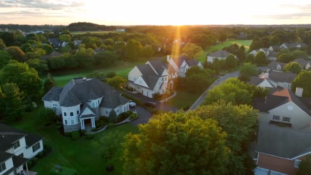 アメリカの近所のコミュニティでマンション ゴルフ場の景色を望むプライベートゲートコミュニティ 劇的な太陽の光 空中展望 富管理のテーマ — ストック動画