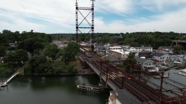 白い雲が立ち並ぶ美しい日に コネチカット州のサウガタック川鉄道橋の上空からの眺め 列車が通過すると橋の真上のカメラトラックが — ストック動画