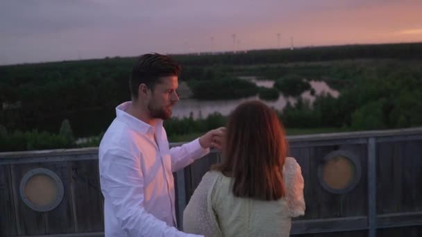 太陽が沈んでいる間に塔の上で踊るカップル — ストック動画