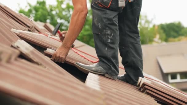 屋根の上に立つ恐れのない男と壊れた粘土瓦 サイドビューを修正 — ストック動画
