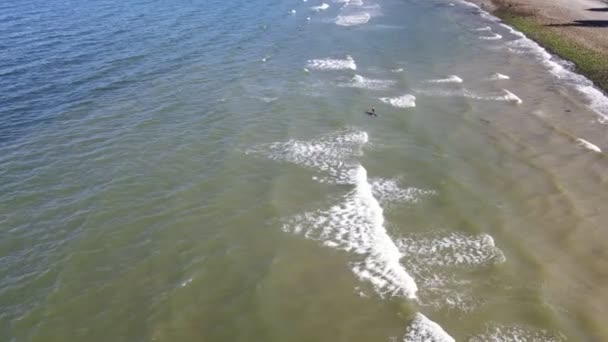 スタンドアップパドルボードの人が敷設し ギブソンズ カナダのBonniebrookビーチで波をパドルを開始します 空中下の傾斜ショット — ストック動画