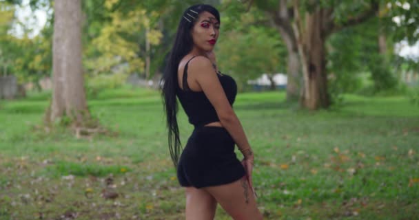 ヒスパニック系の女性の服を着てすべて黒で長い髪で熱帯公園の設定 — ストック動画