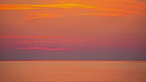 明るいオレンジ色の夕日は 空を横切る賢明な雲として海の水を反射します 時間の経過 — ストック動画