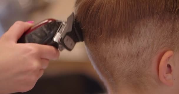 Zbliżenie Ujęcia Tyłu Głowy Fryzjer Przycinający Włosy Dla Dziecka Pomocą — Wideo stockowe